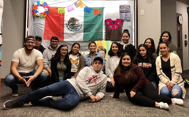 Students huddle around Latinx Heritage Month display